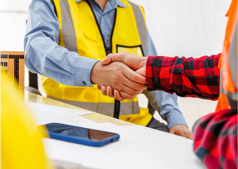 Workers shaking hands at site