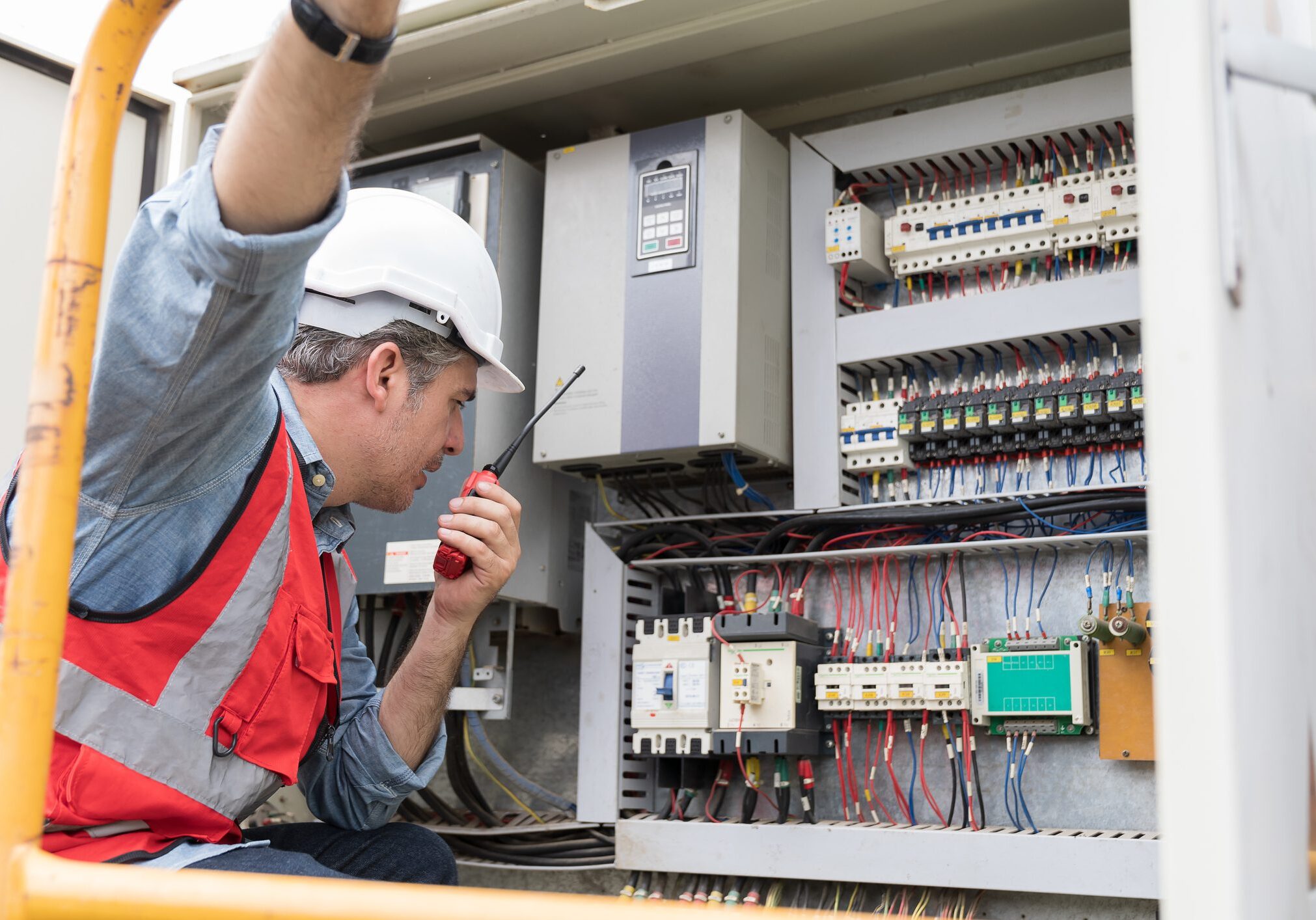 Male electrician checking, repair, maintenance operation electric system in crane construction site